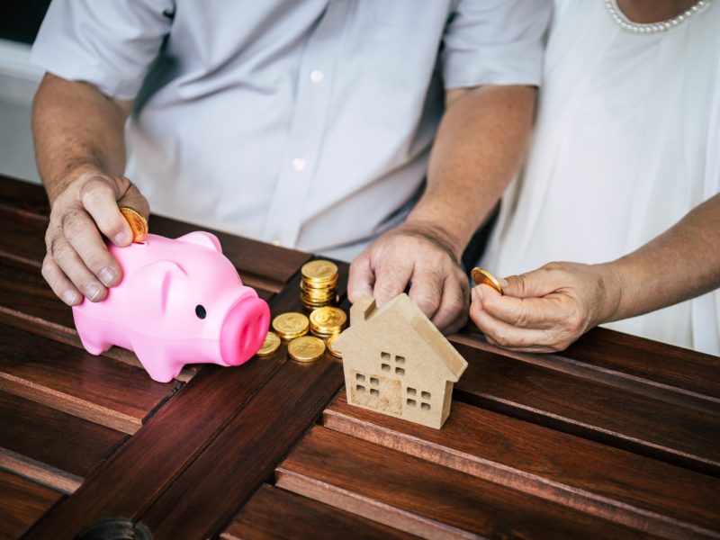 elderly-couples-talking-about-finance-with-piggy-bank